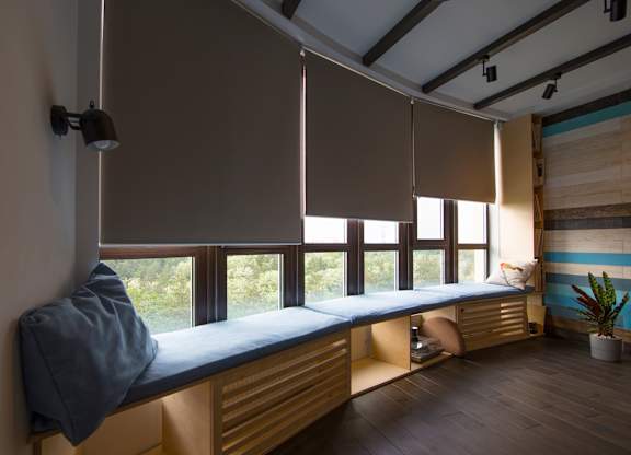 A room with a window seat and a potted plant.