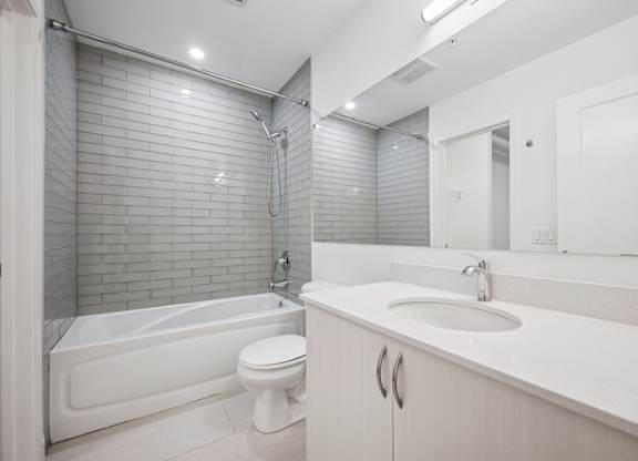 Modern bathroom with subway tile and white vanity at Ophelia on Queen Apartments, Kitchener, ON