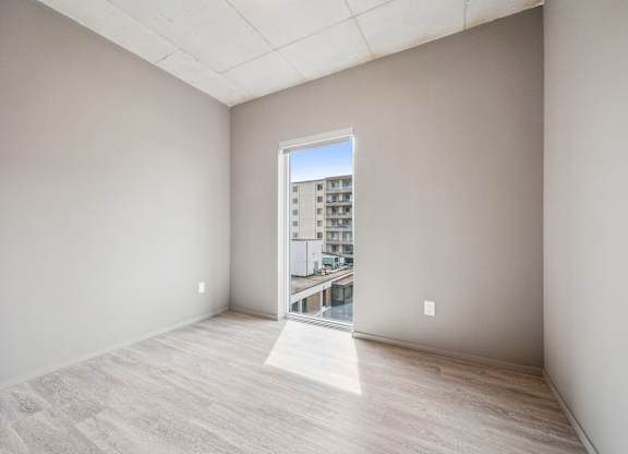 Bright bedroom with balcony door and views at Ophelia on Queen Apartments, Kitchener