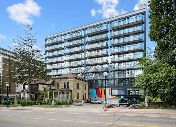 Modern glass facade building with balconies at Ophelia on Queen Apartments, Ontario
