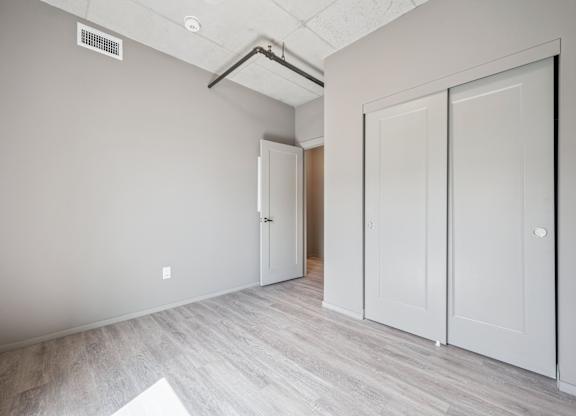 Empty bedroom with closet and neutral tones at Ophelia on Queen Apartments, Ontario, N2G 0E7