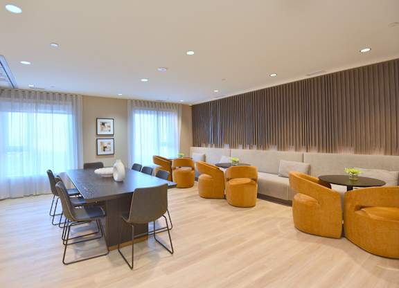 A modern dining room with a long table and chairs at Roxy Apartments, Hamilton, ON, L8H 0B7