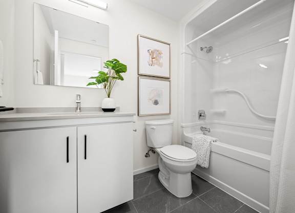 A white bathroom with a toilet, sink, and bathtub.