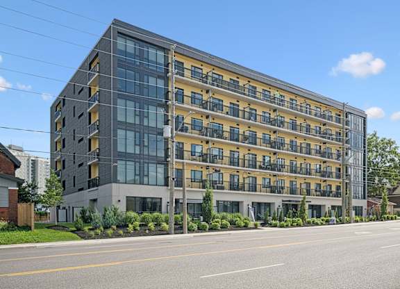 Contemporary midrise building with yellow facade and glass at The Maverick Apartments, Kitchener, N2H 0E3