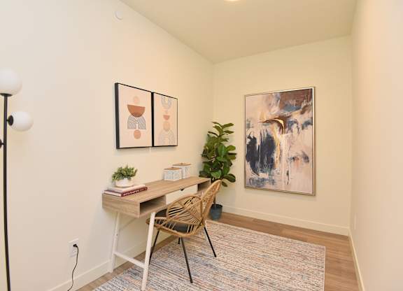 A room with a desk and chair in front of a painting at Roxy Apartments, Hamilton