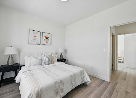 A bedroom with a large bed and two nightstands with lamps at Roxy Apartments, Hamilton, Ontario