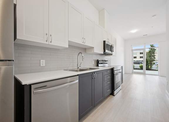 Galley kitchen with white and gray cabinetry at The Maverick Apartments, Kitchener, Ontario