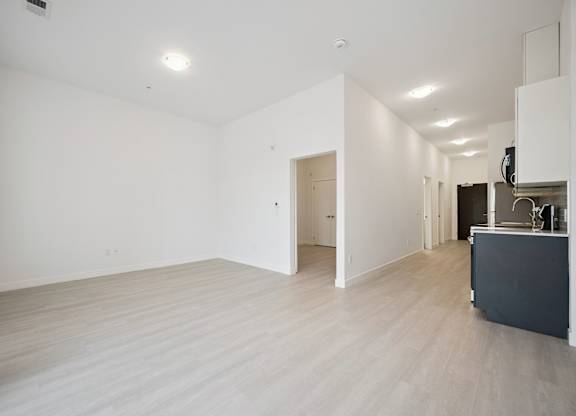Spacious open layout with light wood flooring at The Maverick Apartments, Kitchener