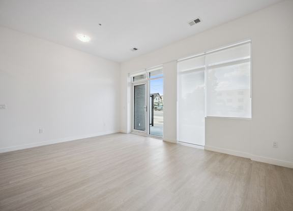 Empty living space with light wood flooring at The Maverick Apartments, Ontario, N2H 0E3