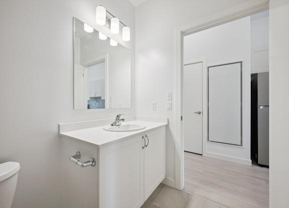 Bright bathroom with vanity and mirror at The Maverick Apartments, Kitchener, ON N2H 0E3