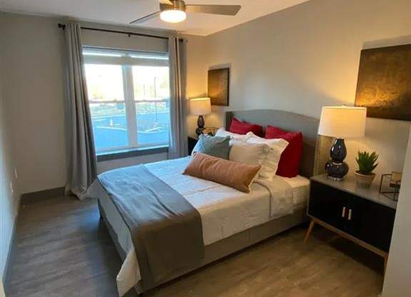 A bedroom with a large bed and a ceiling fan. at Latitude at Riverchase, Hoover, Alabama