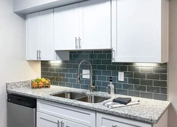 A kitchen with white cabinets and a granite countertop. at Latitude at Riverchase, Hoover
