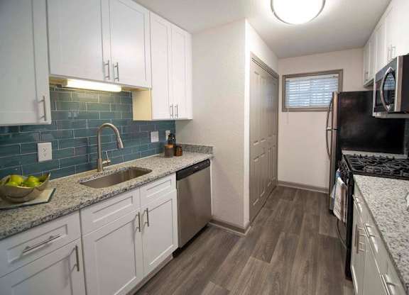 A kitchen with white cabinets and a black stove top oven. at Paces Ridge at Vinings, Georgia