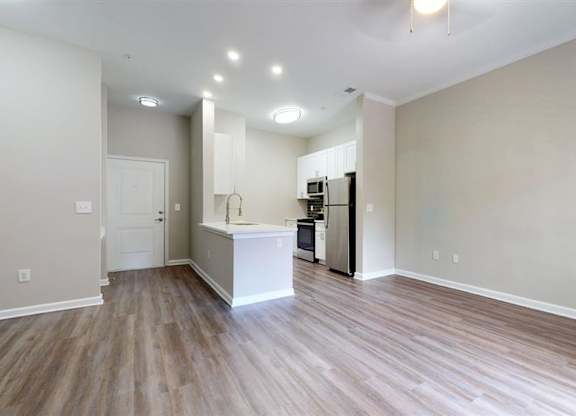 A kitchen area with a white countertop and wooden flooring. at Vue at Embry Hills, Atlanta, GA, 30042