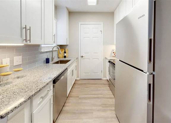 A kitchen with white cabinets and a granite countertop. at Breckinridge Vue, Duluth, Georgia