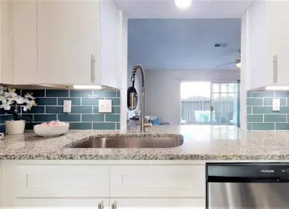 A kitchen with a stainless steel dishwasher and white cabinets. at Cumberland Pointe, Georgia, 30080