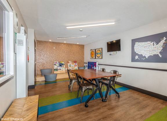 A room with a table and chairs and a map of the United States on the wall.