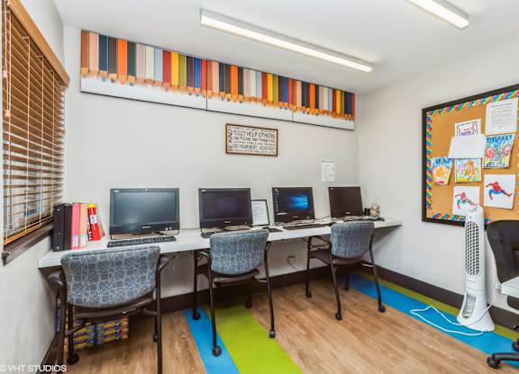 A room with a bulletin board and four computers at Oak Center Apartments, Oakland, CA, 94607
