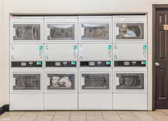 A row of white ovens with blue labels on them at Oak Center Apartments, California, 94607