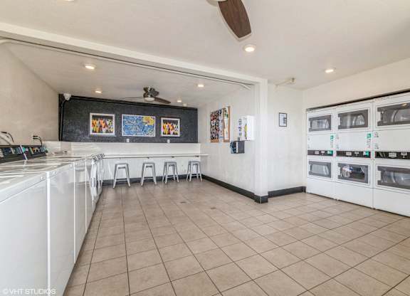 A kitchen with white appliances and a fan on the ceiling at Oak Center Apartments, California