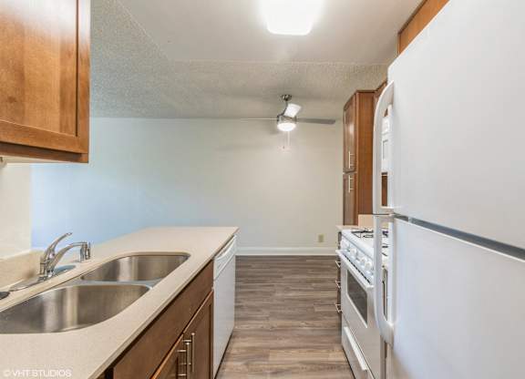 A kitchen with a white refrigerator, stove, and oven at Oak Center Apartments, Oakland, CA