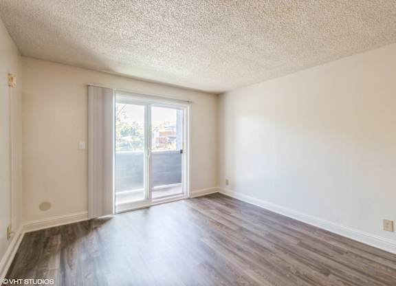 A room with a sliding glass door leading to a balcony at Oak Center Apartments, Oakland