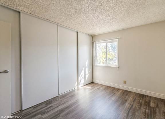 A room with a window and wooden floors at Oak Center Apartments, Oakland, California