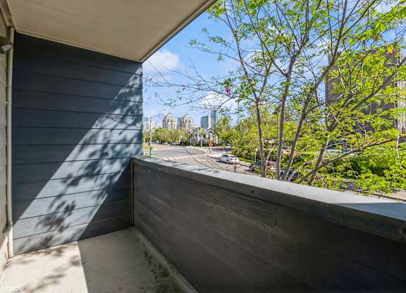 A balcony with a view of a cityscape and trees. at Oak Center Apartments, Oakland, CA, 94607