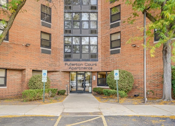 The image shows the front of Fullerton County Apartments with a brick facade and a glass door entrance at Fullerton Court Apartments, Illinois 60614