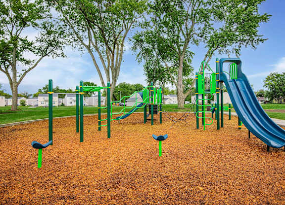 A playground with a green slide and a blue slide at Poplar Place Apartments, Springfield