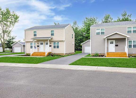 Two houses are side by side with a road in between at Poplar Place Apartments, Illinois