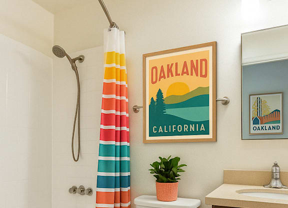 A bathroom with a toilet, sink, and a poster of Oakland California.