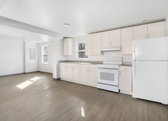 A white kitchen with wood floors and white appliances at Poplar Place Apartments, Springfield, 62703