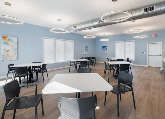 A room with tables and chairs and a painting on the wall at Poplar Place Apartments, Springfield, IL