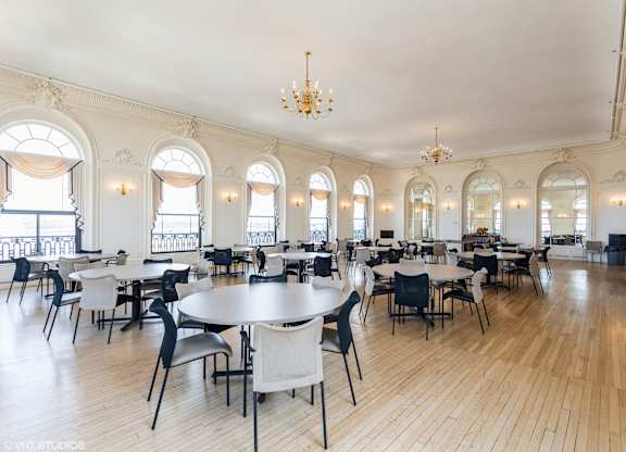 A large room with tables and chairs and a chandelier at Mohican Apartments, Connecticut