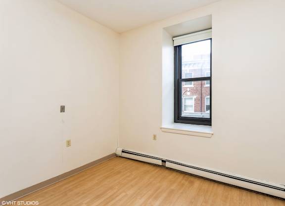 A room with a window and a wooden floor at Mohican Apartments, New London, CT
