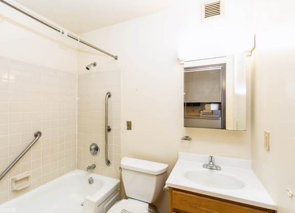 A white bathroom with a toilet, sink, and bathtub at Mohican Apartments, New London, Connecticut