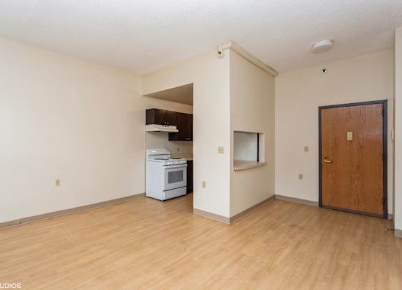 A kitchen area with a white oven and wooden door at Mohican Apartments, New London, CT, 06320