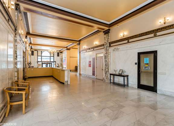 A spacious room with a wooden floor and a large window at Mohican Apartments, New London