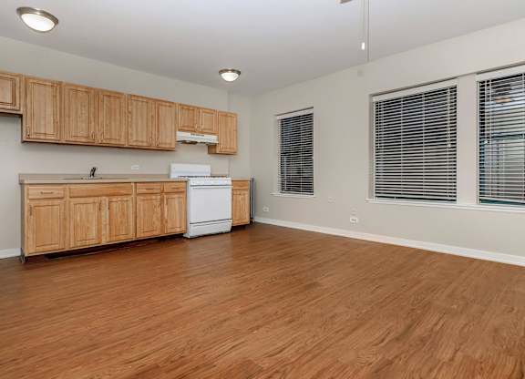 A kitchen with wooden cabinets and a white fridge at Sheridan Park, Chicago, IL