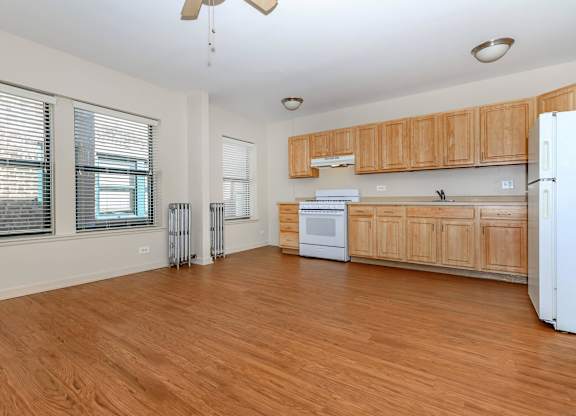 A kitchen with wooden cabinets and a white refrigerator at Sheridan Park, Chicago, IL 60640