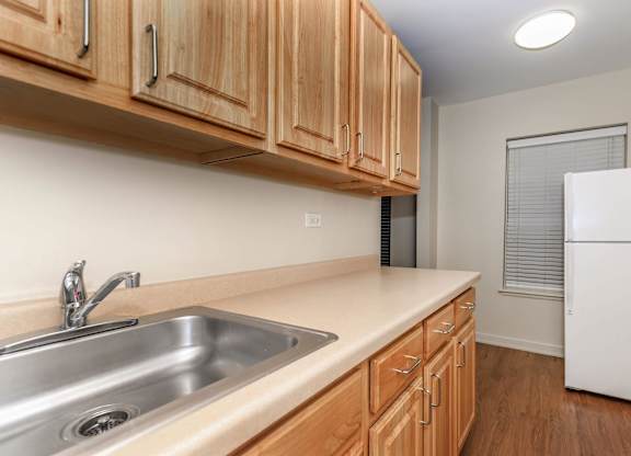 A kitchen with wooden cabinets and a white refrigerator at Sheridan Park, Illinois
