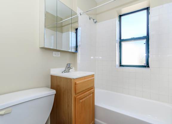 A white toilet sits next to a sink in a bathroom at Sheridan Park, Chicago, Illinois