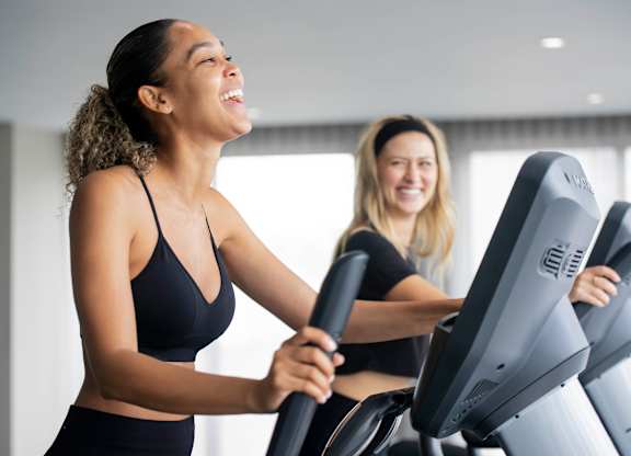 Two women are exercising on treadmills in a brightly lit room. at Palma, Florida