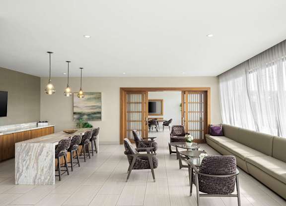A modern living room with a dining area and a large window. at Palma, Doral