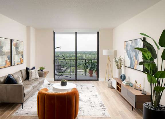 A living room with a large window overlooking a balcony with a view of the ocean. at Palma, Florida