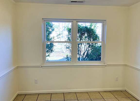 A room with a large window and tiled floor.