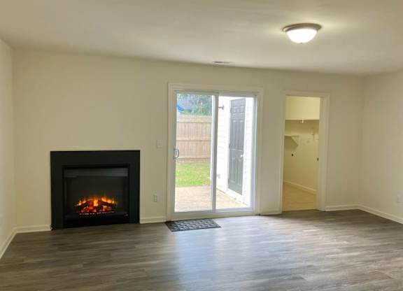 A room with a fireplace and sliding glass doors.