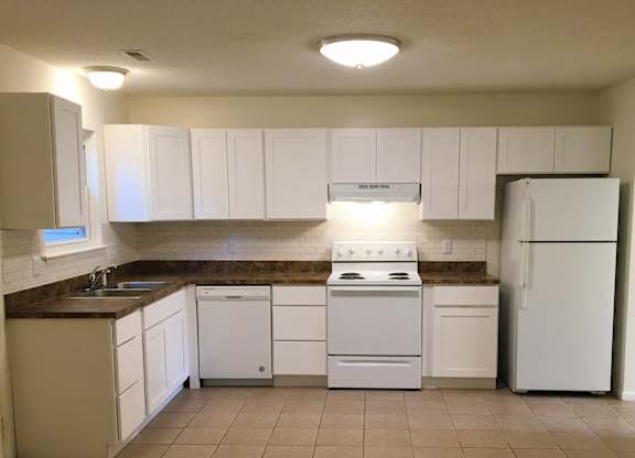 A kitchen with white appliances and cabinets.