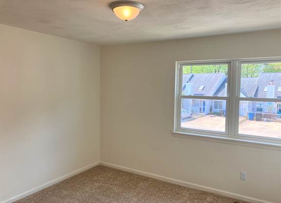 A room with a window and a ceiling light.